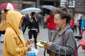 '风雨中人们驻足了解真相，签名反迫害'