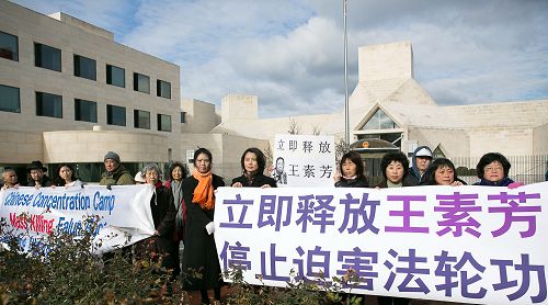 二零一四年十二月十日中午，居住在美国大华府地区的华裔居民王素玲和部份当地法轮功学员在中共驻美国大使馆前举行新闻发布会，责令中共当局立即释放被非法绑架、关押的王素玲的姐姐王素芳以及所有被中共非法拘押的法轮功学员。