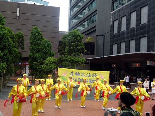 图5：部份腰鼓队的法轮功学员还表演了腰鼓，很多民众鼓掌照相