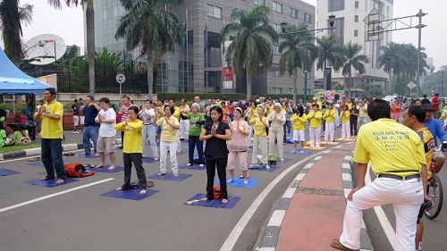 图：雅加达法轮功学员在周日无车日集体炼功，吸引着人们的目光，并驻足了解法轮功。