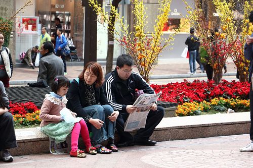 大陆游客在尖沙咀闹市，拿过真相的报纸后凝神细看