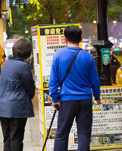 很多大陆游客把握时间看法轮功真相展板