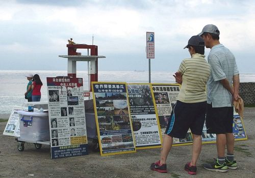 图4：花莲七星潭海边，游客观看法轮功真相展板