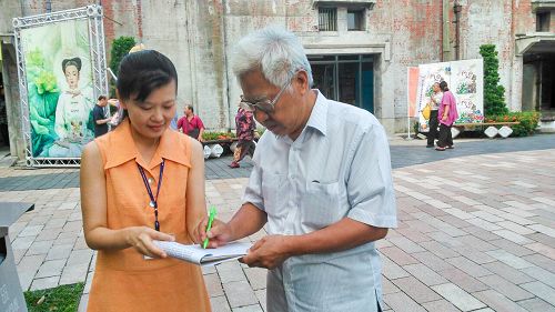 图说4 书法家高连永正在“刑事举报江泽民”联署书上签名。