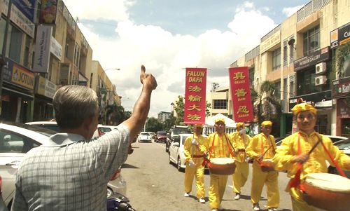 图11：老居民在路旁竖起拇指，不停的赞叹“好！好！好！”。