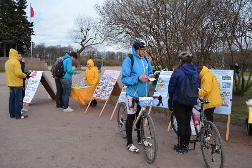 图3-5:许多民众经过时,有的驻足阅读真相展板、真相资料,有的与学员交谈了解迫害真相。