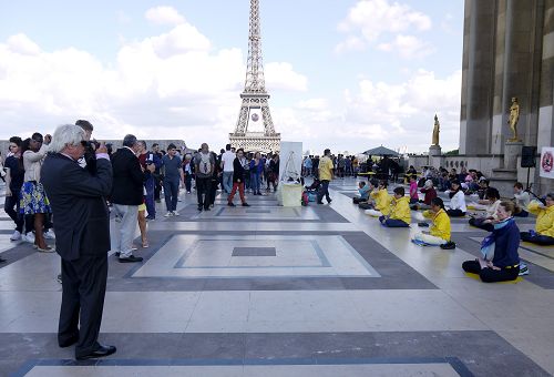 图1-3：二零一六年六月二十六日下午，法轮功学员在巴黎艾菲尔铁塔下的人权广场上传播真相。图为法轮功学员祥和的功法场面和真相展板都吸引了中西游客的目光。