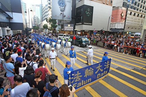 '图4：由法轮功学员组成的队伍，在天国乐团引领下，游行九龙区旺角、佐敦，再到尖沙咀广东道，抵达终点天星码头。沿途吸引港民及中西旅客观看。'