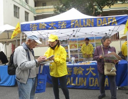 '图1：二零一六年九月十日和十一日，法轮功学员在旧金山中国城的“中秋街会”上设立展位，向民众讲述法轮功的真相，并征集“制止中共活摘”的签名。许多华人签名支持。'