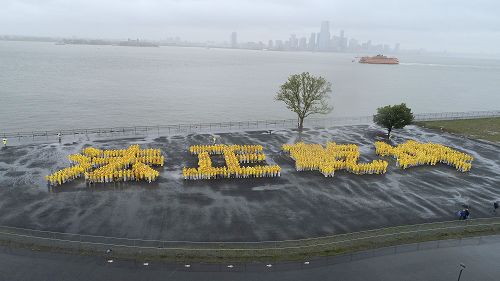 图1：庆祝“世界法轮大法日”，法轮功学员冒雨排出“法正乾坤” 四个大字。