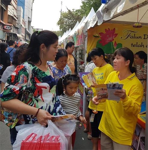 '图1：法轮功学员在文化节上向华人讲真相'