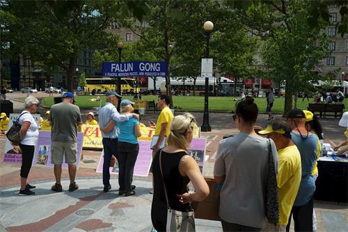 '图4：波士顿市科普利广场上，法轮功学员向民众讲真相'
