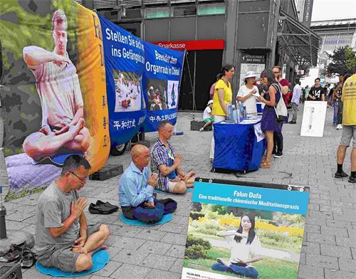 '图1：二零一八年八月四日，汉堡法轮功学员在位于市中心的火车站前设立信息点，传播法轮功的真相，揭露中共的迫害。'