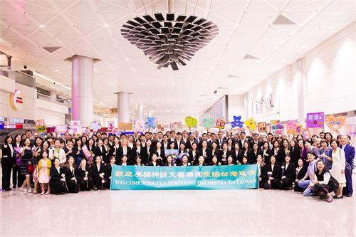 '图1：美国神韵交响乐团九月十二日清晨抵达台湾桃园国际机场，热情粉丝机场迎接，献花、跟神韵交响乐团艺术家合影。'