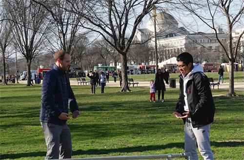 '图2：一位年轻的游客（右）在国家广场学炼法轮功。'