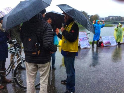 '图7:波兰法轮功学员在雨中向游客讲真相'