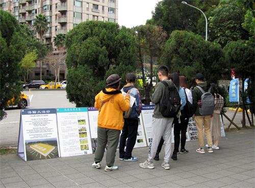 图7～8：大陆游客观看展板内容并聆听法轮功学员讲真相。