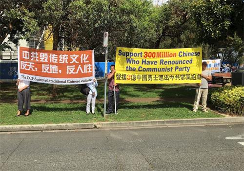 '图1～2：法轮功学员在华人聚集区展示法轮功和平反迫害的信息'