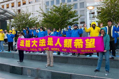 '图12～15：法轮功学员在联合广场举办纪念“‘四·二五’上万名中国法轮功学员北京和平上访二十周年”活动。图为法轮功学员正在演示功法。'