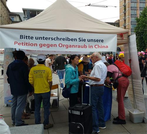 '图1～11：法轮功学员在德国名城弗莱堡市中心举办了法轮功信息日，人们驻足了解真相并签名支持法轮功反迫害'