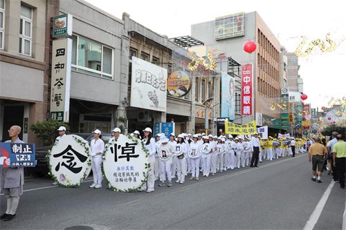 '图7：学员衣着净白素服，手捧被迫害致死的大陆法轮功学员照片，圣洁静肃行进。'