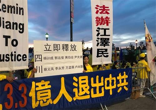 '图9：来自四川的法轮功学员常小春打出展板，要求立即释放四川省绵竹市多名法轮功学员，法办迫害元凶江泽民。'