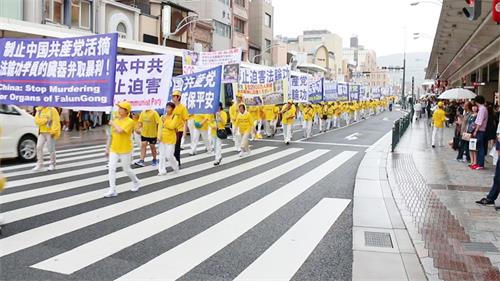 '图3～5：随后，法轮功学员反迫害二十周年游行队伍出现在繁华的京都大街上，引来许多游客驻足观看。'