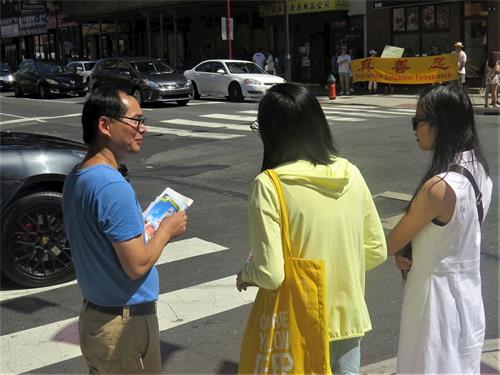 '图4：两位年轻华裔在了解法轮功是什么'