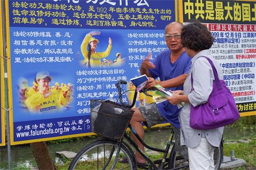 '图10～13：二零一九年七月二十日，高雄法轮功学员聚集在凤凌广场，举行法轮功反迫害二十周年集会活动。图为真相图片展、反迫害征签。不少过往民众驻足关注。'