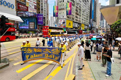 图6：反迫害游行队伍经过港岛区闹市，沿途吸引许多民众观看。