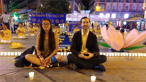 '图2：1：2019年7月19日，在马德里Callao广场，Marta小姐 和Alberto先生主动留下来和法轮功学员一起，席地而坐，烛光守夜。左边是 Marta， 右边是Alberto'