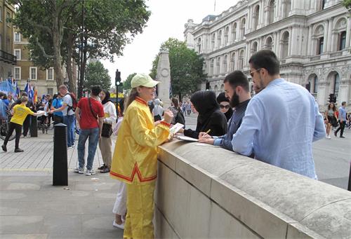 '图10：二零一九年七月二十日，在唐宁街10号首相府前，民众在了解真相后签名支持法轮功反迫害。'