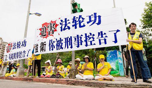 '强卫车队行至高雄佛光山山区，法轮功学员早以醒目的标语和强大声浪等待，告诉强卫：“你恶贯满盈”、“你被告了”。'