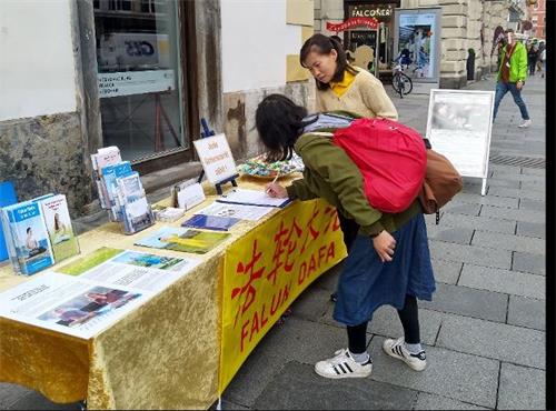 '图5：一位来自台湾了解真相的女士来到展位前签字并表达她对法轮功的支持'