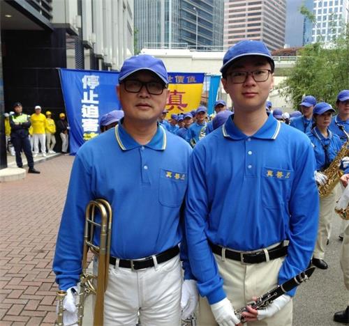 '图1：二零一八年元旦，李先生父子俩作为天国乐团的成员，参加了在香港举行的法轮大法集会游行贺新年活动。'