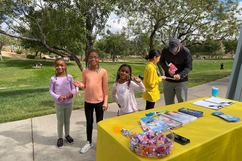 图10:一大群孩子跑来询问是什么活动啊拿着学员送他们的系有法轮大法好小卡的小莲花,开心地合影留念。