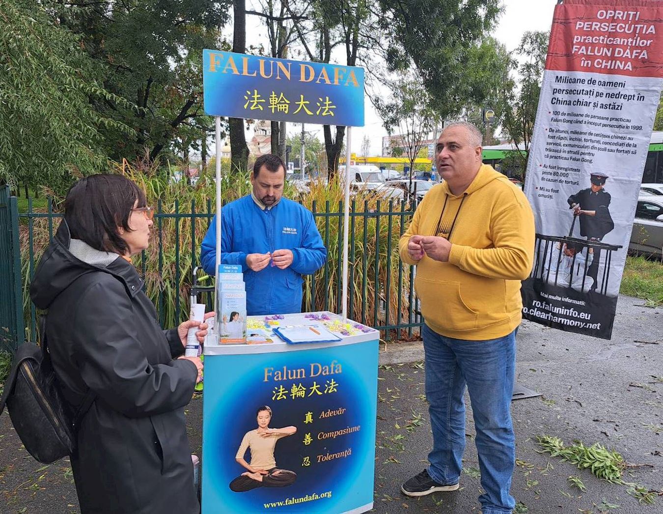 '图7:二零二五年十月四日,在布加勒斯特的法轮功展台,学员和当地人交谈'