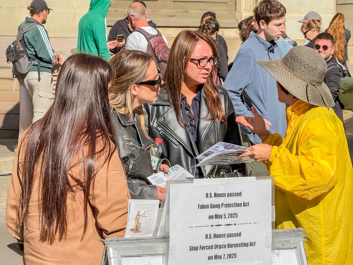 '图9~12:在真相展位前,很多游客在与学员的交谈中了解了法轮功真相。'