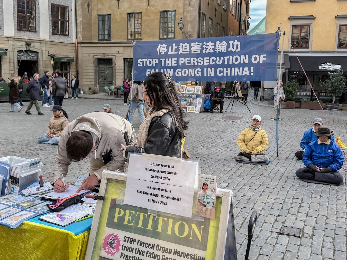 '图3~8:游客在现场阅读真相资料,明真相后签名支持法轮功。有对功法感兴趣的当场学炼功动作。'