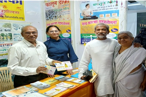 图11:拉文德拉·科尔赫博士和斯米塔·科尔赫来到法轮功展位前,并鼓励学员。