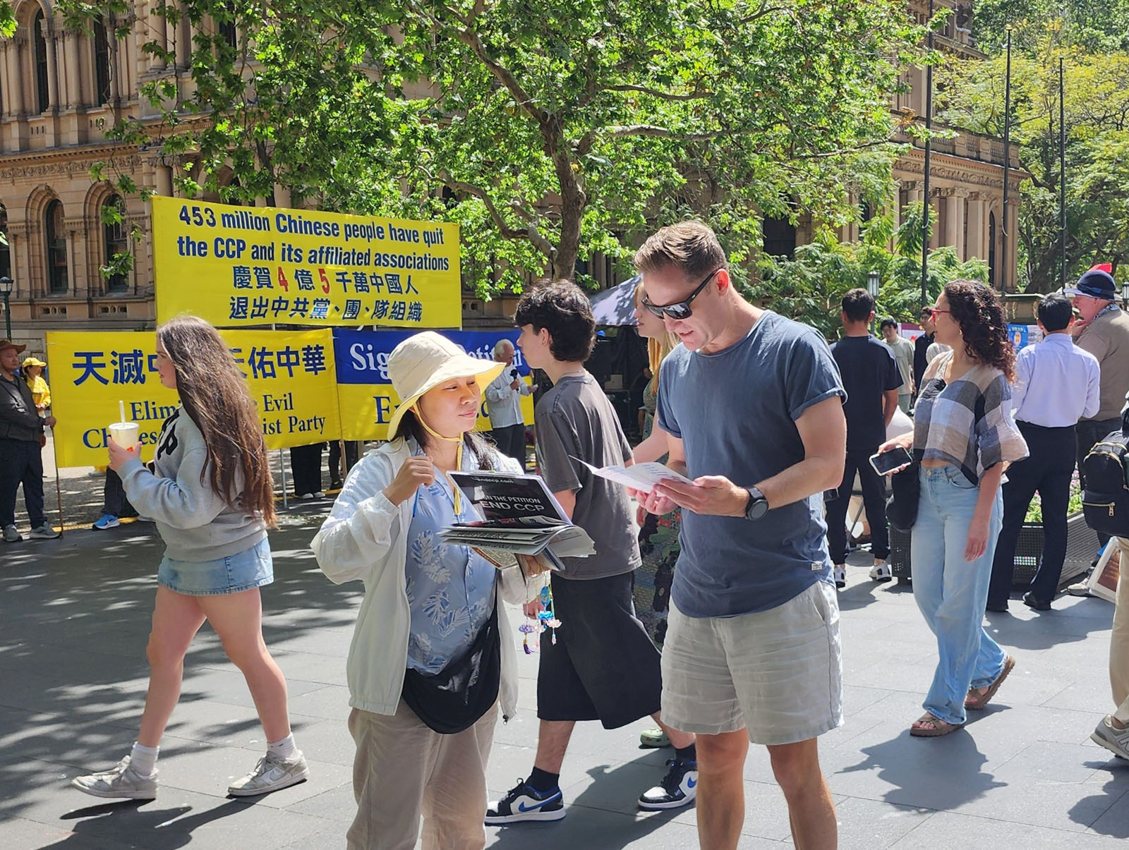 图10~13:不少路人驻足聆听嘉宾发言,与法轮功学员交谈,并以签名的方式表达声援。