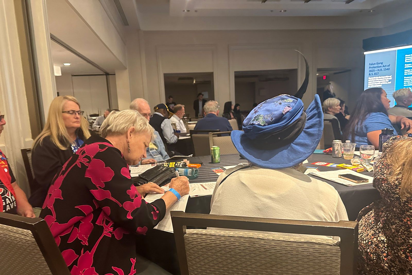 图4~5:一些观众在观看电影后,当场在呼吁制止中共迫害的请愿书上签名。