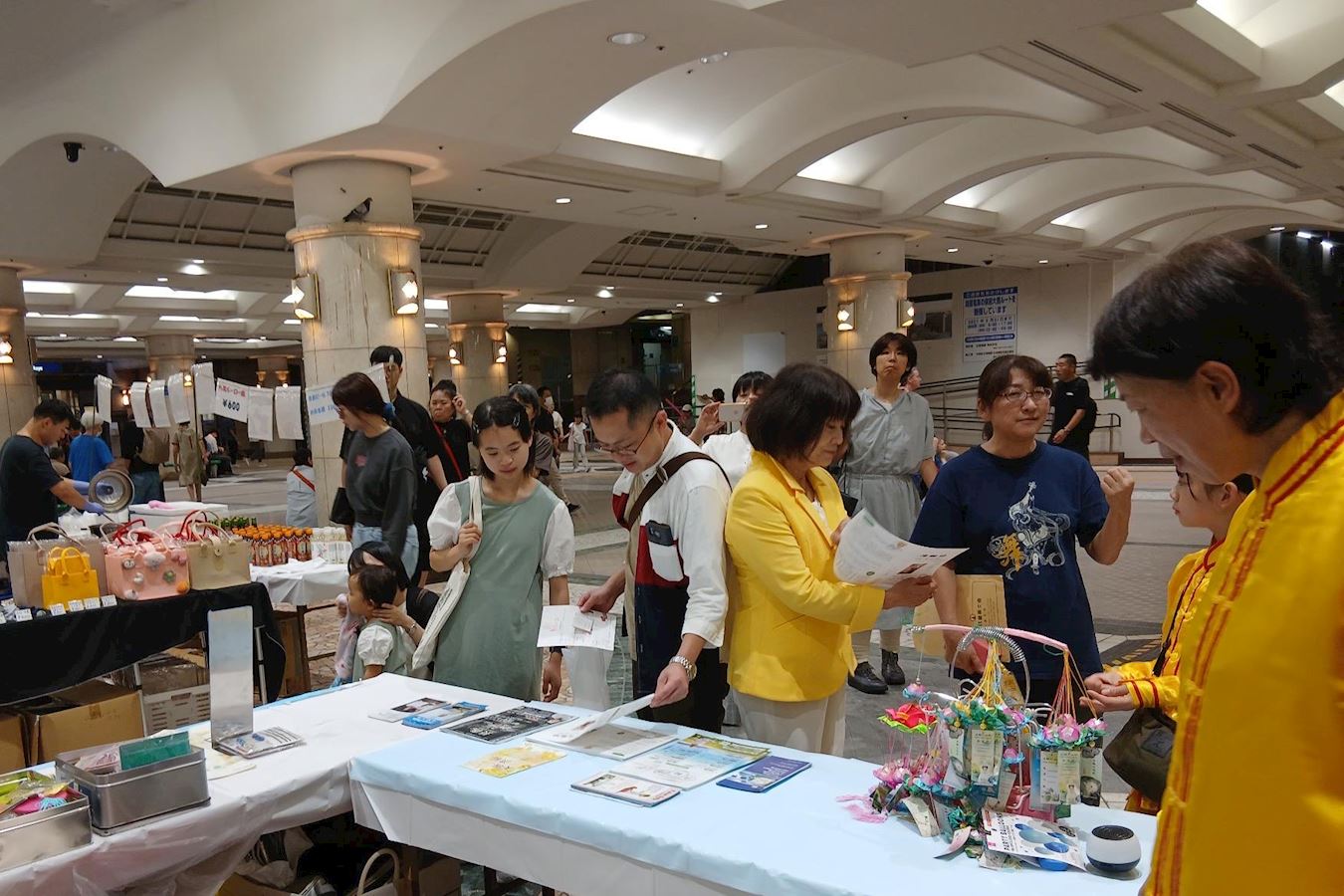 '图4:民众来到法轮功展位前主动拿资料阅读。'