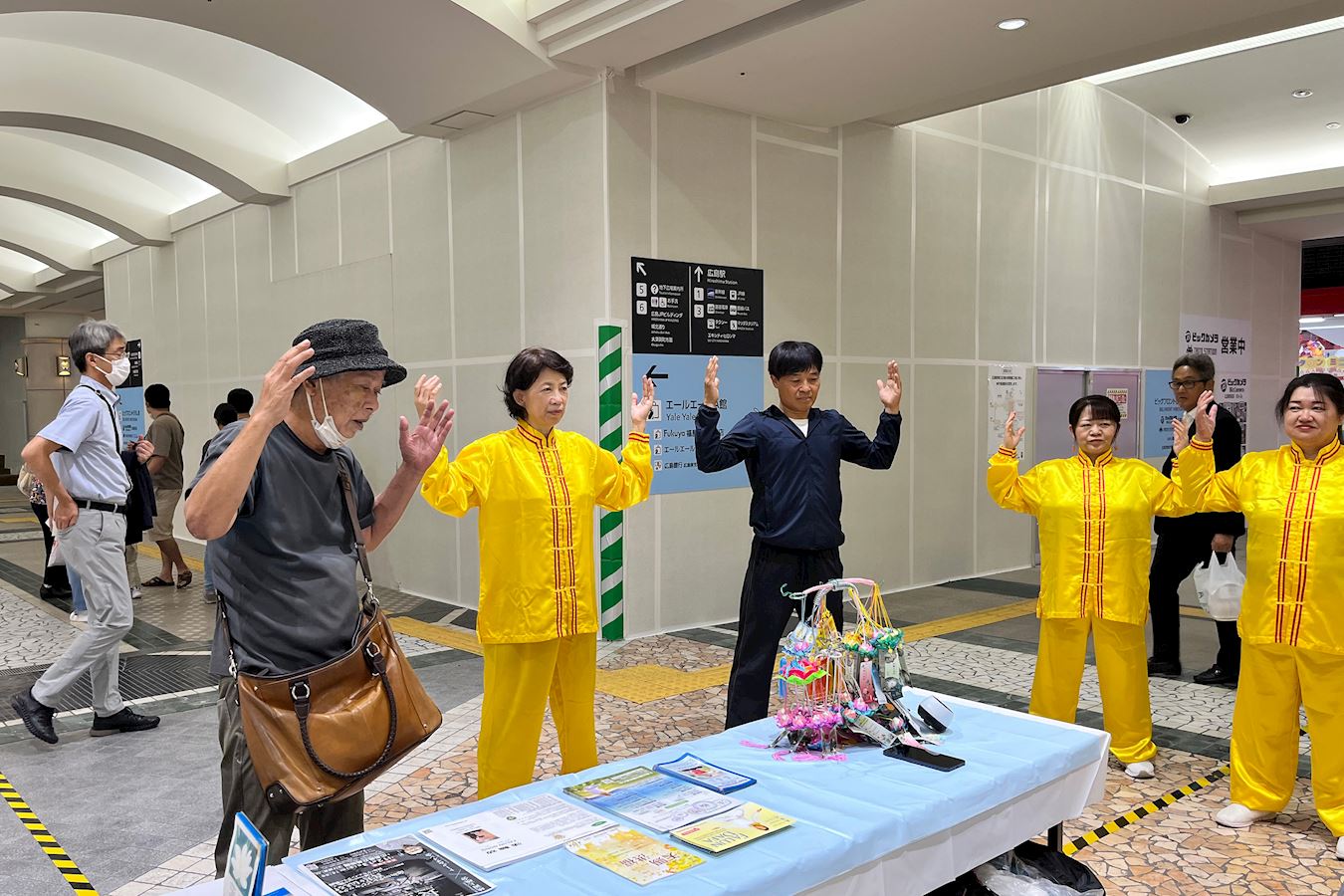 '图6:田村先生在展位前学炼功法。'