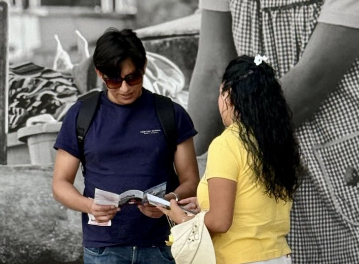 图12~13:法轮功学员与当地人交谈,传播真相