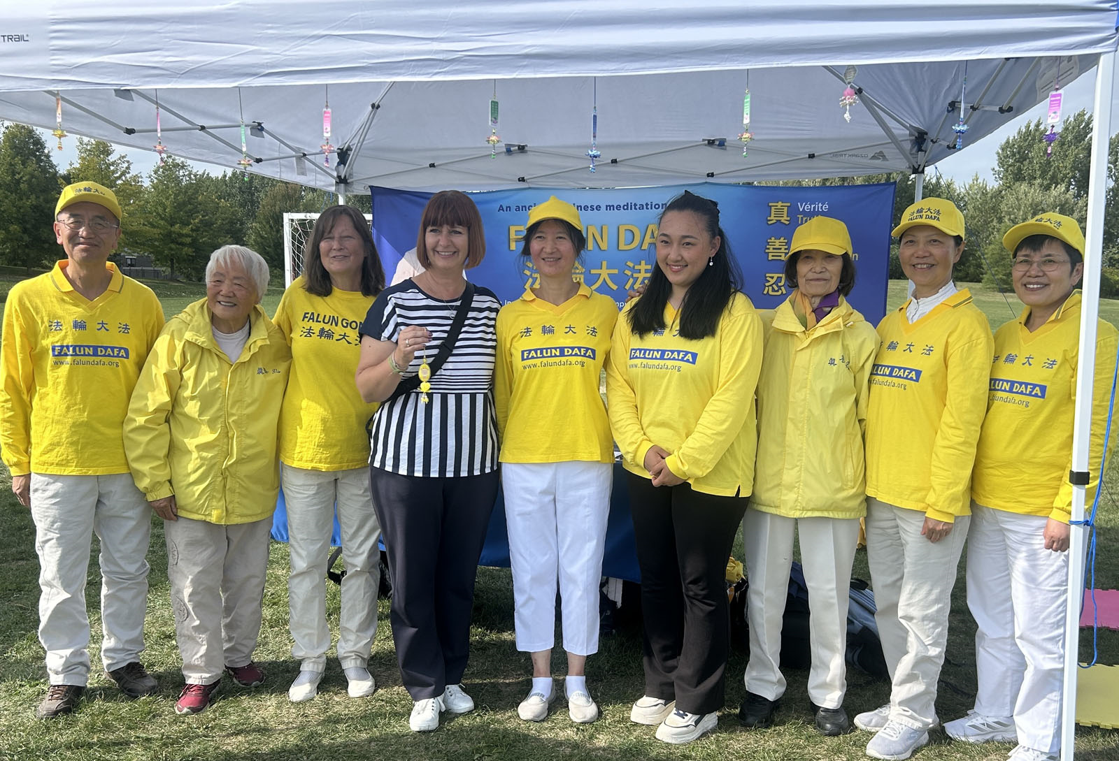 图2:在奥尔良多元文化节上,国会议员拉朗德(左四)在法轮功展位前与学员合影。