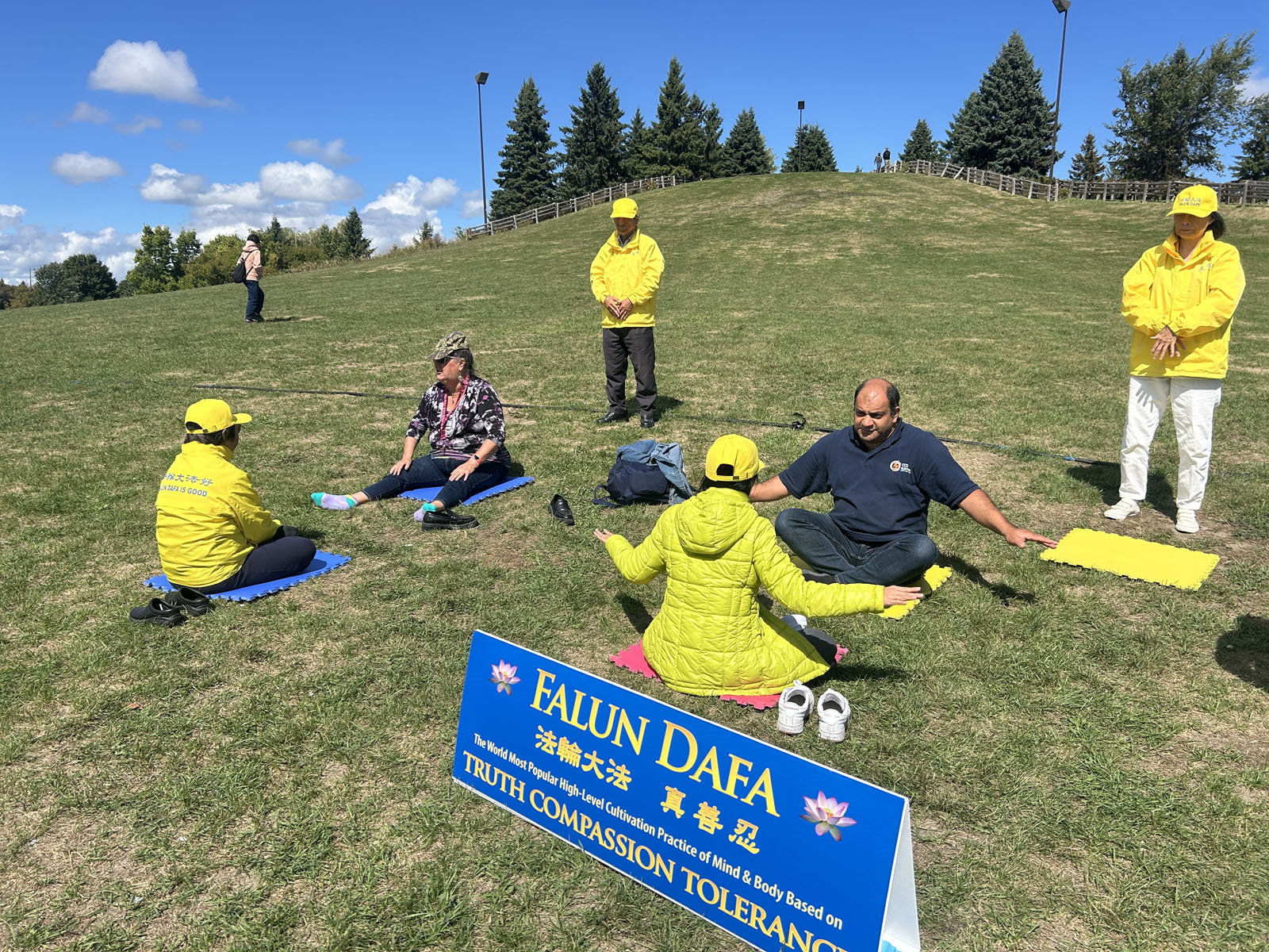 图8:九月七日,在首都的西面的卡纳塔社区举办的文化节上,电力工人兼企业主赫贾齐(右二)表示,打坐让他感受到身体与心灵的变化,并激发了他想要深入修炼的渴望。