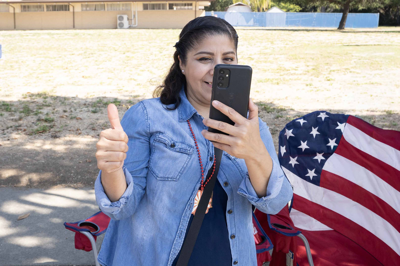 图19:观看游行的劳拉女士为法轮功的队伍用手机拍照留念,并竖起大拇指。