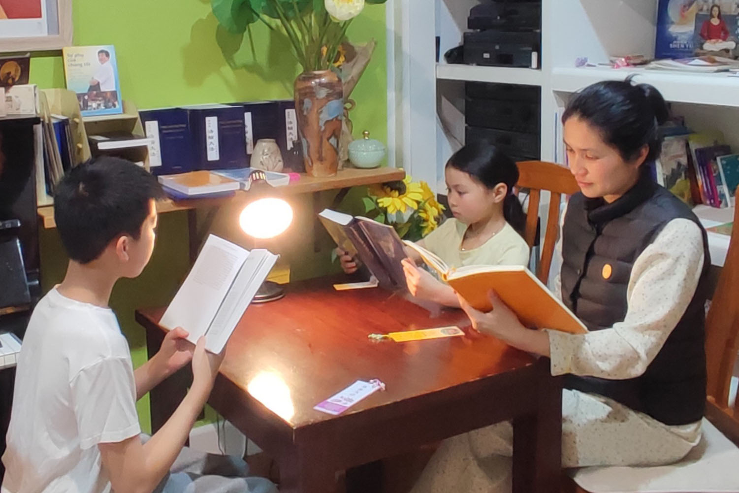 图15:墨尔本法轮功学员阮氏芳清和一双儿女一起阅读《转法轮》。