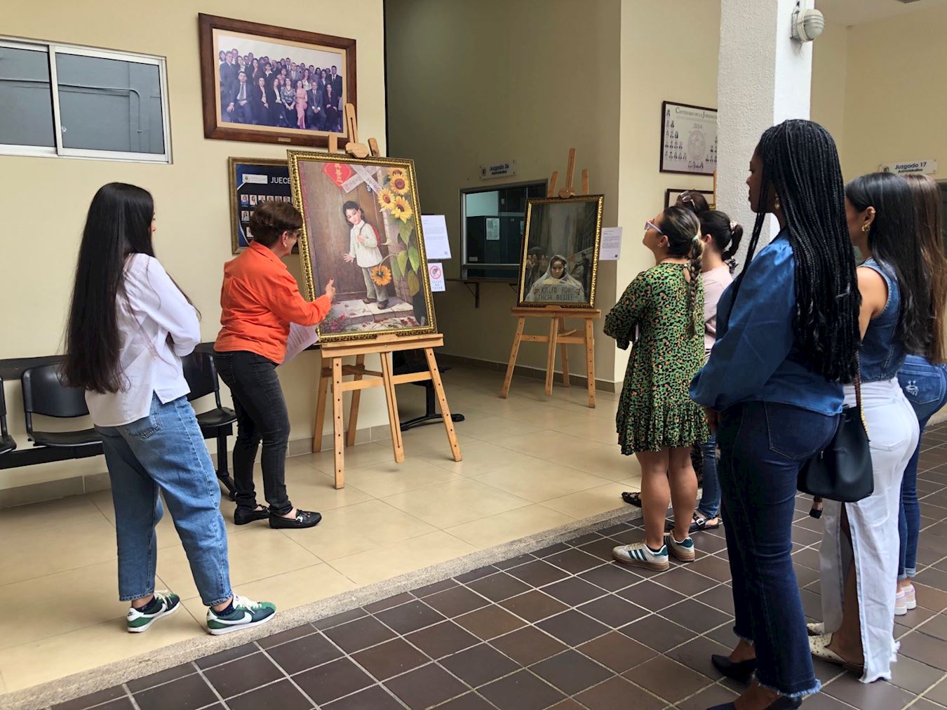 '图1:学法轮功员为阿特拉斯大楼的法官和工作人员提供美展导览。'